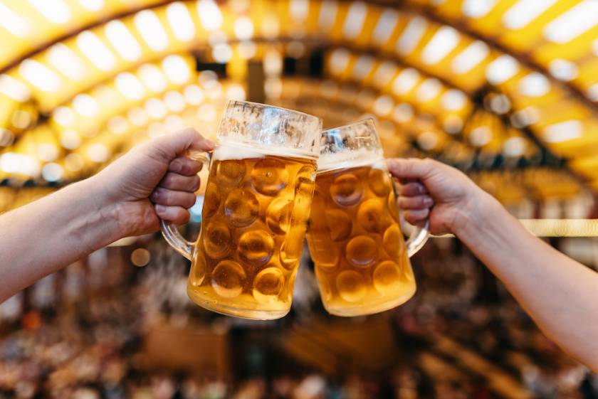 close up on two beer steins clinking at oktoberfest